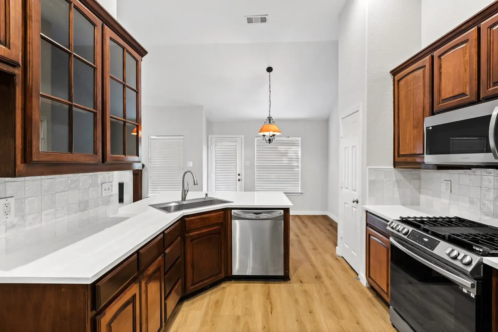 Carrara quartz kitchen counters on cherry cabinets with a subway tile backsplash in Frisco, TX